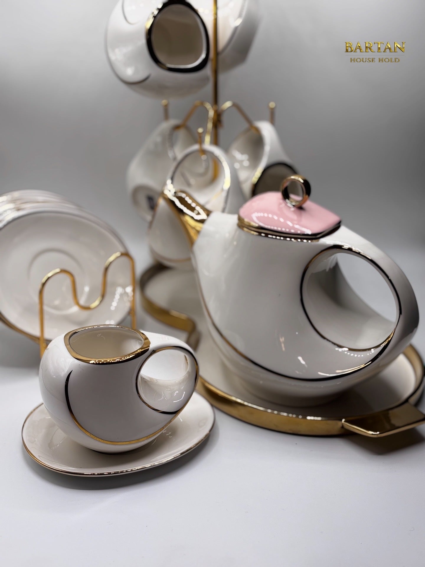 White ceramic tea set with gold accents on a light gray background, featuring the brand 'Bartian'.