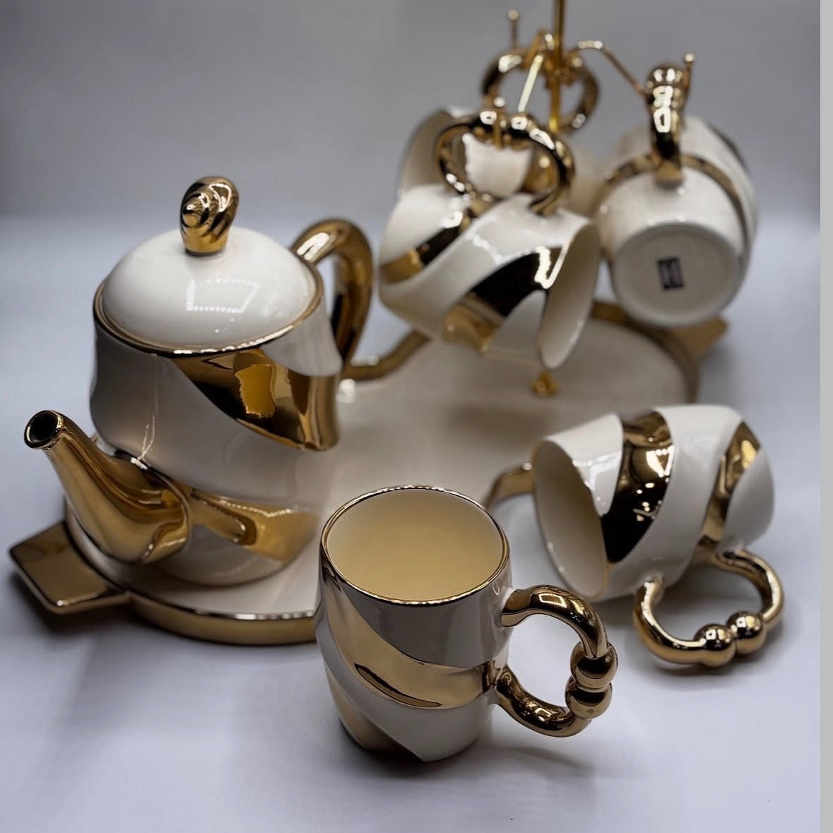 White ceramic tea set with gold accents on a white background