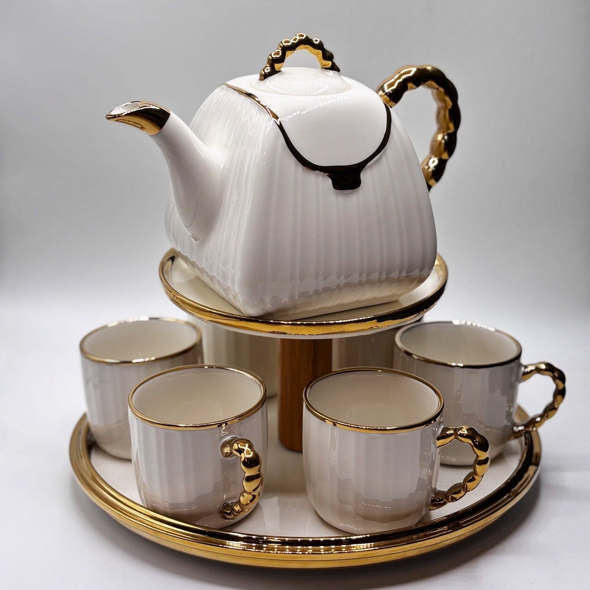 White teapot and four cups with gold accents on a tray, featuring the BARTAN brand.