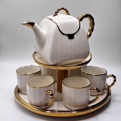 White teapot and four cups with gold accents on a tray, featuring the BARTAN brand.