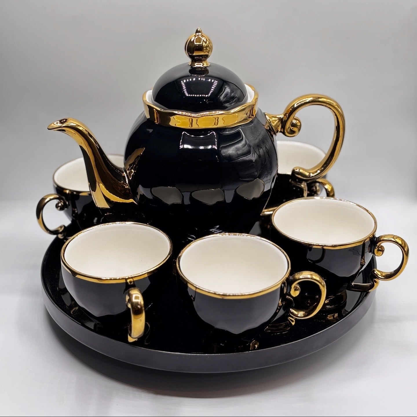 Black and gold teapot set with four cups on a tray, featuring the BARTAN House Hold brand.